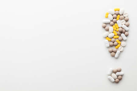 Blank white background with tablets arranged in exclamation mark. Place for text.の写真素材