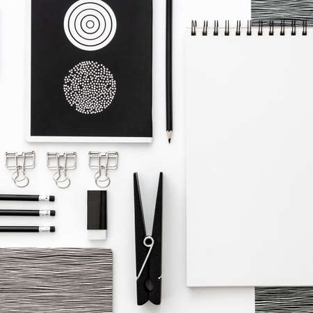 Flat lay skretch book mockup with black frame and office supplies on white background. Top view mockup. Blog template. Black and white geometrical concept.の写真素材