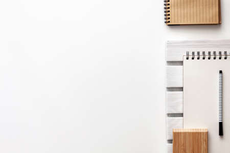 Creative desk with office supplies. Notebook, sketchpad, felt-tip pen and wooden pad. Copy space for text. View from above. Minimalist compositionの写真素材