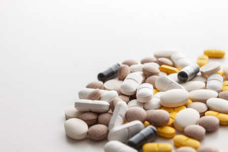Scattered colorful pills on a white background. Copy space. Pharmacology.の写真素材
