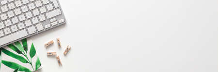 White office desk with copy space. Keyboard and bamboo pattern. View from above. Panoramaの写真素材