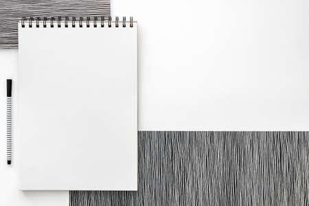 Blank spiral bound sketchbook with empty open page. Top view real photo. White background for text. Copy space. Black and white minimal conceptの写真素材