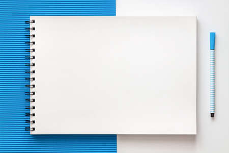 White school creative desk with blue elements. Space for text. Sketchbook mockup. Real photo, top view. School accessories. Geometrical compositionの写真素材