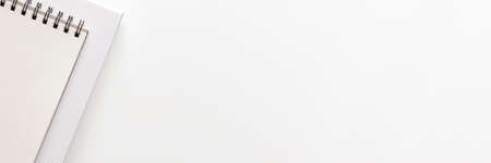 White office desk with empty space for text. Copy space. Office accessories such notebook and paper. Panoramic view from the top. Black and white composition. High keyの写真素材