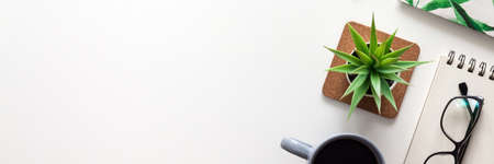 White office desk with copy space. Open notebook, glasses, coffee and succulent. View from above. Panoramic photoの写真素材