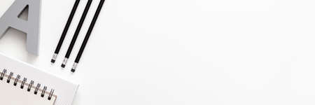White office desk with empty space for text. Copy space. Office accessories such as pencils and notebook. Panoramic view from the top. Black and white compositionの写真素材