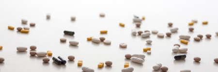 Scattered pills on a white background. Copy space. Nobody. Medicine. Panoramic photoの写真素材