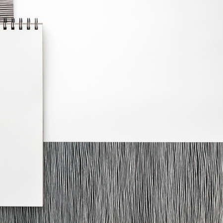 Blank spiral sketchbook with empty open page. Top view real photo. White background for text. Copy space. Black and white minimal conceptの写真素材