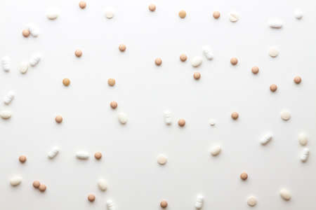 Scattered pills on a white background. Bright monochrome composition. Pharmacologyの写真素材