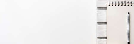 Creative desk with office supplies. Notebook, sketchpad, felt-tip pen and wooden pad. Copy space for text. View from above. Minimalist composition. Panoramic real photoの写真素材