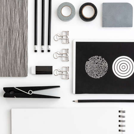 Flat lay skretch book with black office supplies on the white background. Top view mockup. Blog template. Black and white geometrical concept.の写真素材
