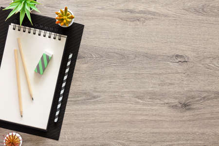 Wooden home desk. Copy space. Open sketchbook and office supplies. Plants. View from above.の写真素材