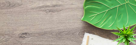 Wooden home desk. Copy space. A ceramic monstera leaf as decoration. View from above. Panorama.の写真素材