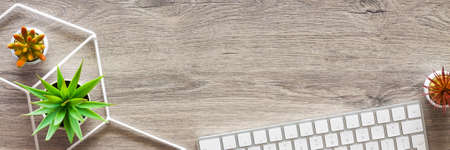 Wooden home desk. Copy space. succulents, a geometric toolbox and a computer keyboard. View from above. Panorama.の写真素材