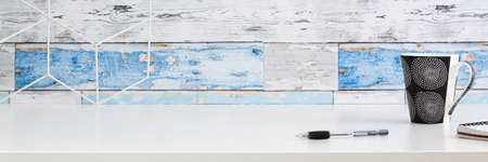 Home office desk. A wall with old boards. Office items. Geometric toolbox. Copy space. Panorama.の写真素材