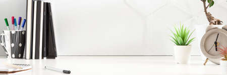 Business desk. Copy space. Office utensils and plants in pots. Notebooks and books. Home office. Geometrical pattern. Panorama.の写真素材