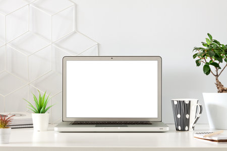 An office by an empty wall. Home Office. School desk. Copy space. Plants at home. Open laptop. Template. Mockup.の写真素材