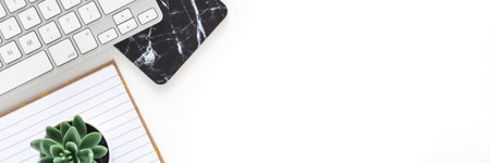 White desk in the office. View from above. Keyboard, open notebook and plant. Copy space. Element with a marble pattern. Panoramic photoの写真素材