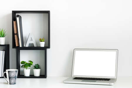 Home office. A desk against a white wall. Copy space. Open laptop. Mockup. Geometric composition. Squares.の写真素材