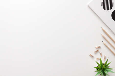 White home office desk. Copy space. Office stuff. Copybook, succulent, wooden pencils. Place for text. View from above.の写真素材