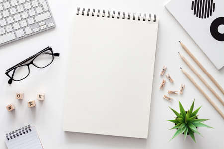 White home office desk. Mockup. Office stuff. Computer, open sketchbook, succulent, glasses, scattered letters WORK. Place for text. View from above.の写真素材