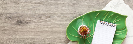 Wooden desk. Top view. Copy space. Decoration. Monstera leaf and notebook. Bannerの写真素材