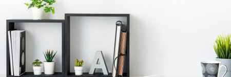 Home office. A desk against a white wall. Copy space. An open book. Geometric composition. Squares. Bannerの写真素材