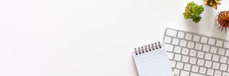 White home desk with computer keyboard. Copy space. Top view. Office supplies. Home office. Banner.の写真素材