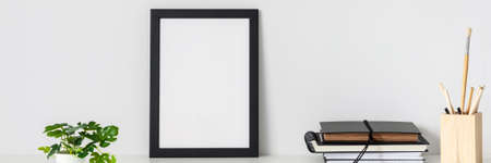 Desk arrangement. Workplace. Mockup frame. Empty wall of copy space. Books and notebooks on the desk. Banner. Panorama.の写真素材