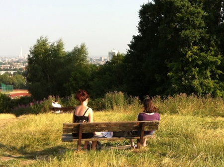 Two women in a park with cityscape view London UKの素材