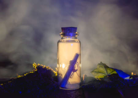 Image of a messag in a stopper bottle and smoke backlit by warm lightの写真素材