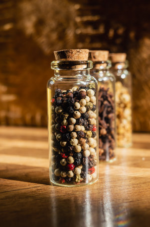 Close-up image of glass stopper bottles filled with spices and herbs on a hardwood surface