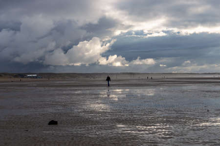 Ijmuiden, The Netherlands November 13, 2021: Man walking on the beach on a cloudy winters day in The Netherlandsのeditorial素材