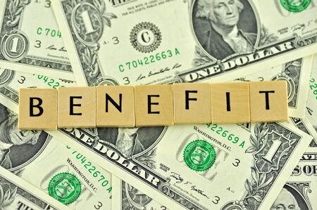 Word benefit in lettern on background of dollar banknotesの写真素材