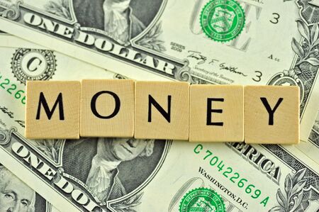 Word money in lettern on background of dollar banknotesの写真素材
