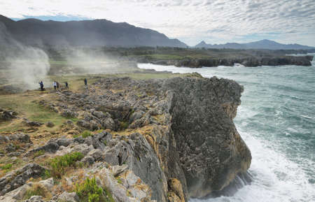 LLAMES, SPAIN - NOVEMBER 3: People walking between spraying water coming from blowholes of Bufones de Pria on November 3, 2013 in villanueva de Pria near Llames village, Asturias, Spainのeditorial素材