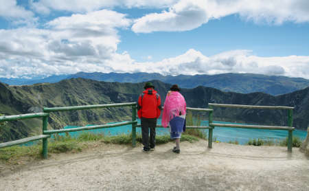 QUILOTOA, ECUADOR - APRIL 19: Ecuadorian ethnic couple looking at view of majestic lagoon in Quilotoa caldera on April 19, 2014 in Quilotoa, Ecuador.のeditorial素材