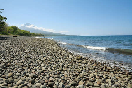 Stony beach with volcano  in Flores island, Indonesia
