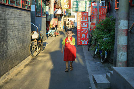 BEIJING, CHINA - SEPTEMBER 06: people walking in a hutong on September 06, 2015 in Beijing, China. Ancient hutongs are formed by alleys that represent an important cultural element of the city of Beijingのeditorial素材