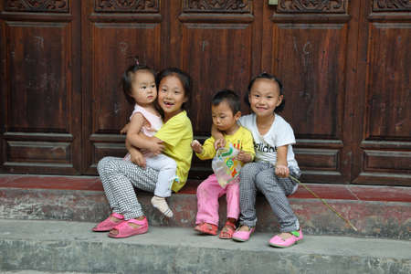 FURONG, CHINA - SEPTEMBER 14, 2015: local chinese kids smiling and looking at camera in tourist and charming ancient Furong (hibiscus) village, Hunan province, China.のeditorial素材