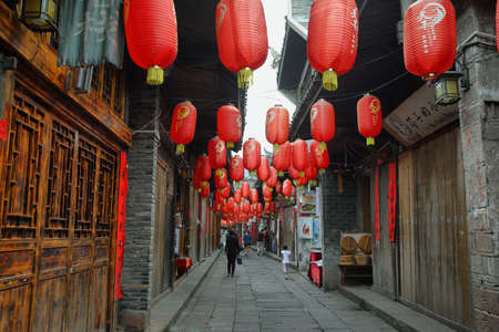 FENGHUANG, CHINA - SEPTEMBER 16, 2015: People walking in a nice decorated street in ancient town of Fenghuang known as Phoenix, Chinaのeditorial素材
