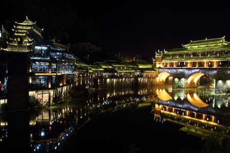 View of illuminated Rainbow bridge and stilt houses in Fenghuang, Chinaの写真素材