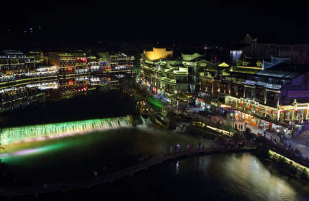 FENGHUANG, CHINA - SEPTEMBER 16, 2015: View of illuminated riverside houses in ancient town of Fenghuang known as Phoenix, Chinaのeditorial素材