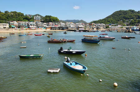 HONG KONG, CHINA - SEPTEMBER 24, 2015: Skyline of the skyscrapers and fishing boats in Lamma island of Hong Kong, chinaのeditorial素材