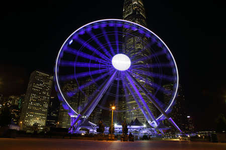 HONG KONG, CHINA - SEPTEMBER 24, 2015: Ferris wheel and skyscrapers illuminated in Victoria Harbour, Hong kong islandのeditorial素材