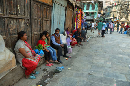 KATHMANDU, NEPAL - APRIL 9 2016: people resting seated aside a promenade in the heart of the old...
