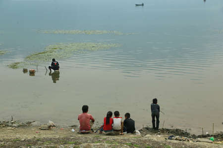 KATHMANDU, NEPAL - APRIL 10 2016: People enjoying of beautiful sunset with red sun at Fewa lake in Pokhara, Nepalのeditorial素材
