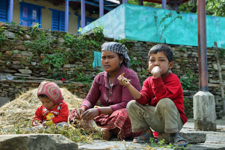 LANDRUK, NEPAL - APRIL 19, 2016: nepalese family resting in the ground in Landruk village. Landruk is a picturesque village along Annapurna base camp hiking trail in Nepalのeditorial素材