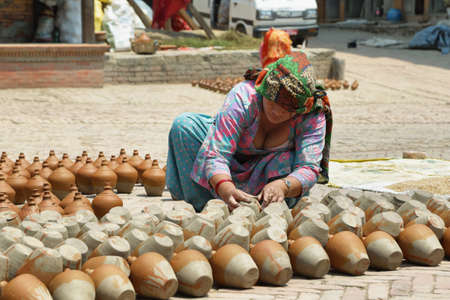 BHAKTAPUR, NEPAL - APRIL 20, 2016: hindu woman working in pottery stand in the middle of Pottery Square in medieval town of Bhaktapur, Nepal.のeditorial素材