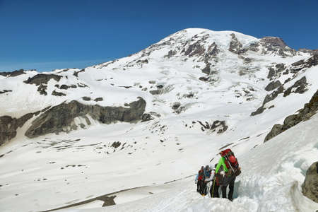PARADISE, USA - JUNE 21, 2016: Group of hikers walking above snow in Skyline trail with Mount Rainier summit at background, Washington, USAのeditorial素材